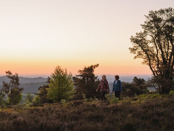 2 Frauen wandern bei Sonnenuntergang, im Hintergrund die Willinger Bergwelt