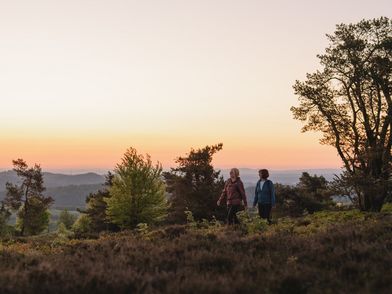 2 Frauen wandern bei Sonnenuntergang, im Hintergrund die Willinger Bergwelt