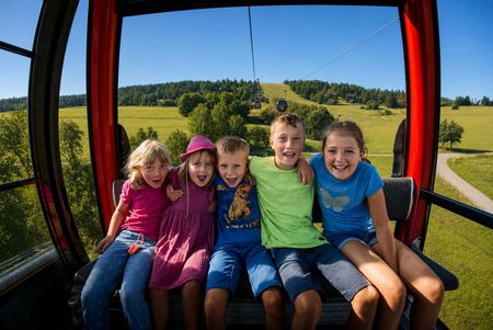 5 Kinder sitzen in einer Gondel der Ettelsberg-Seilbahn 
