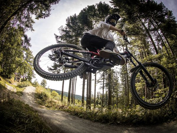 Biker beim Sprung und Akrobatik auf der Freeridestrecke im MTB Zone Bikepark Willingen