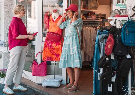 Frauen beim Shopping in Willingen, eine probiert einen Hut auf