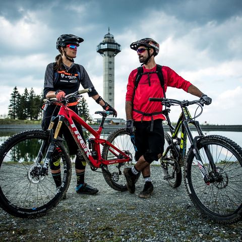2 Mountainbiker am Bergsee auf dem Ettelsberg in der Bikewelt Willingen, im Hintergrund der Hochheideturm und Tannen
