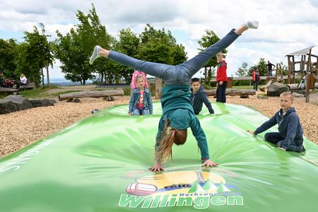 Kindergruppe auf dem Hüpfkissen auf dem Ettelsberg, ein Mädchen macht einen Handstand
