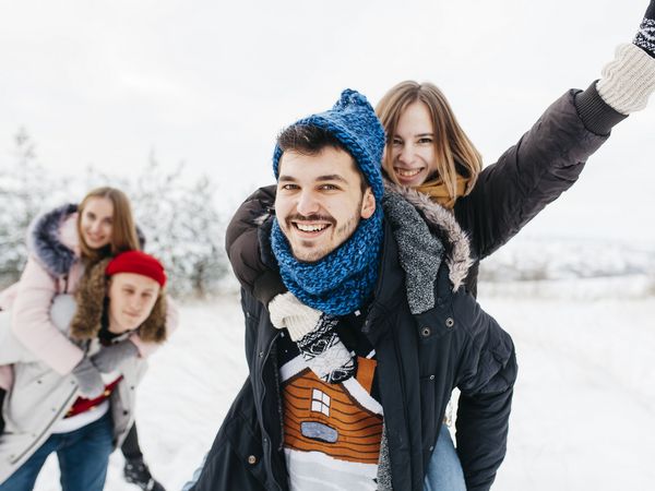 Gruppe junger Leute tollt im Schnee