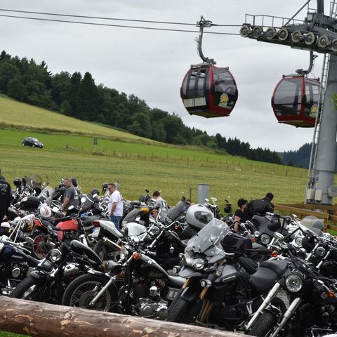 Motorräder an der Talstation der Ettelsberg-Seilbahn mit Gondeln im Hintergrund