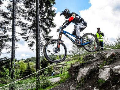 Streckenposten beim Bike-Festival Willingen neben einem Biker beim Sprung