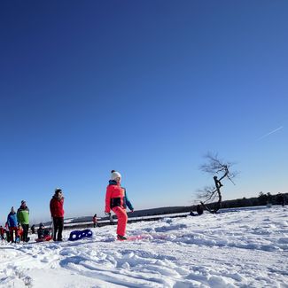 Familie mit Kindern beim Winterwandern am verschneiten Bergsee auf dem Ettelsberg in Willingen