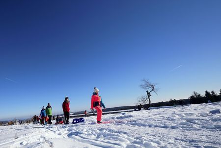 Familie mit Kindern beim Winterwandern am verschneiten Bergsee auf dem Ettelsberg in Willingen