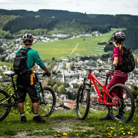 2 Mountainbiker in der Bikewelt Willingen auf dem Orenberg mit Blick auf den Ort
