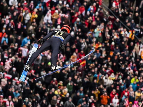 Skispringer in der Luft über den Zuschauern beim FIS Skisprung Weltcup Willingen