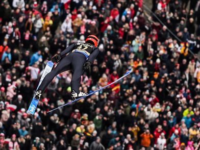 Skispringer in der Luft über den Zuschauern beim FIS Skisprung Weltcup Willingen